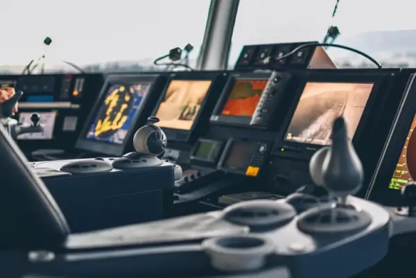 Panel de control de un barco más grande con pantallas y joysticks